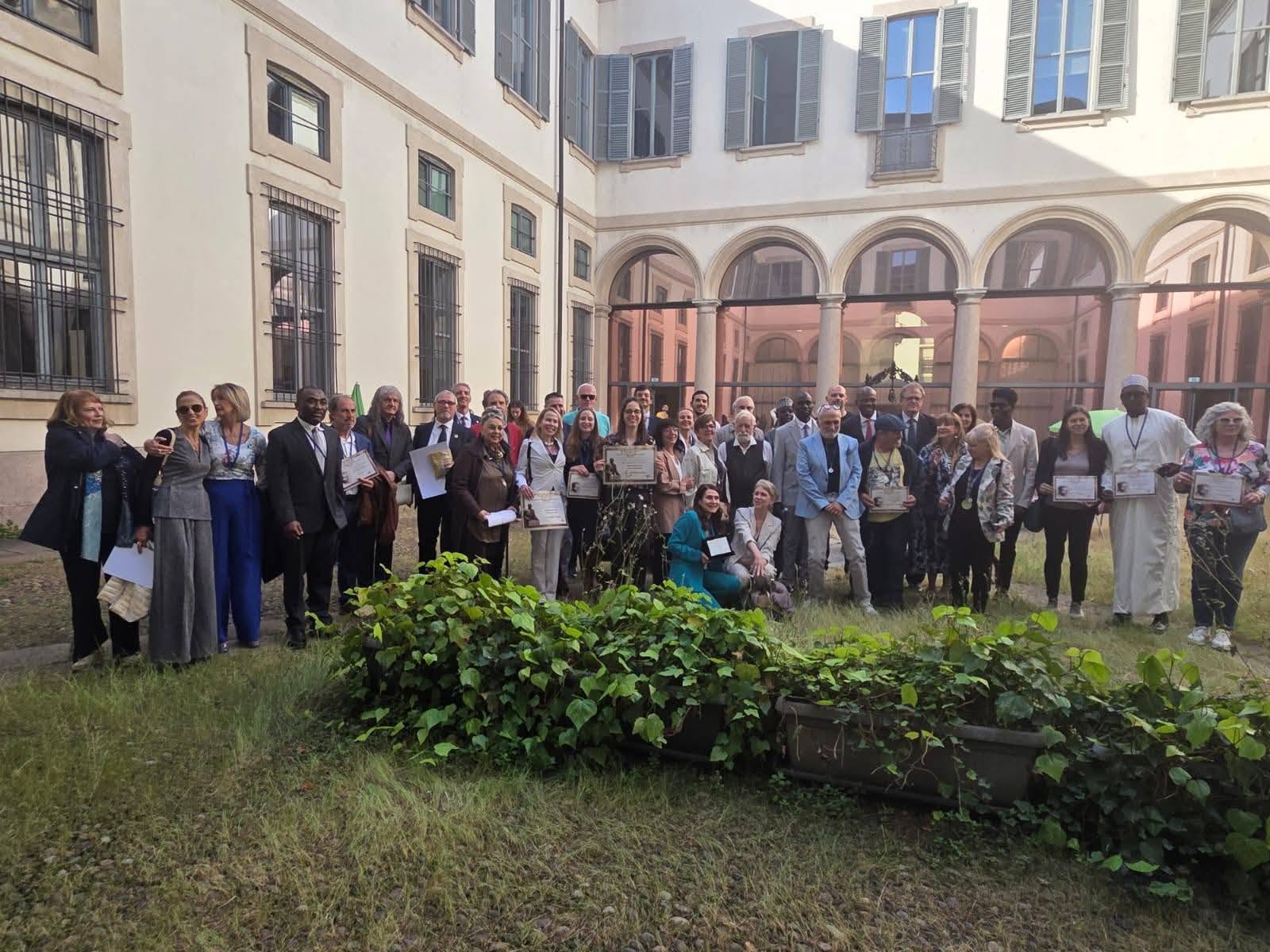 Un groupe de participants pose avec ses diplômes dans une cour.